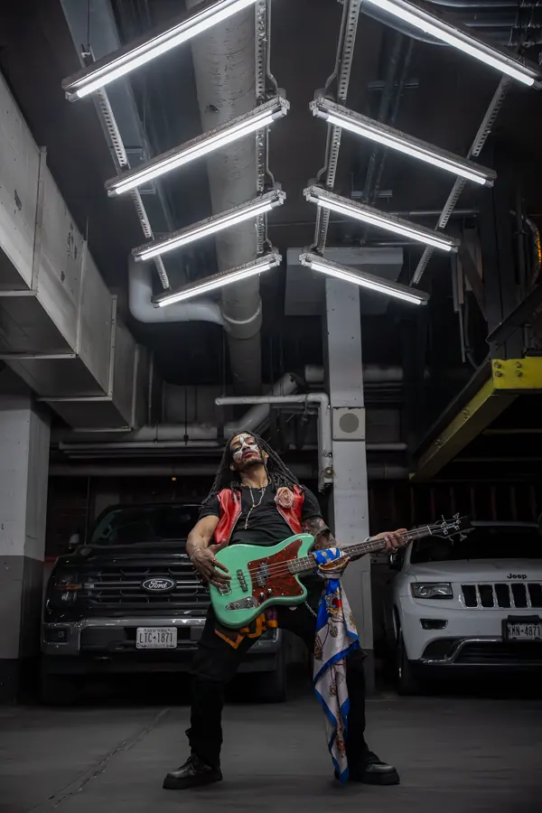 Guitarist performing in a parking garage under fluorescent lights