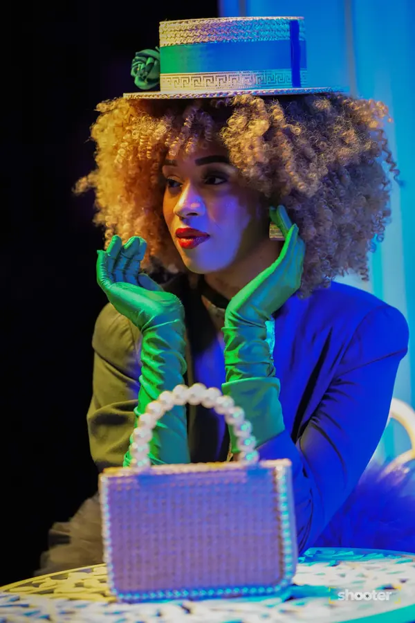 Colorful editorial portrait with a pearl handbag and green gloves