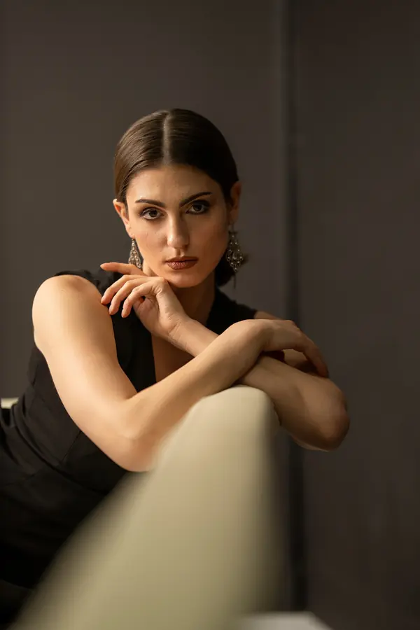 Woman resting on the arm of a chair in soft window light