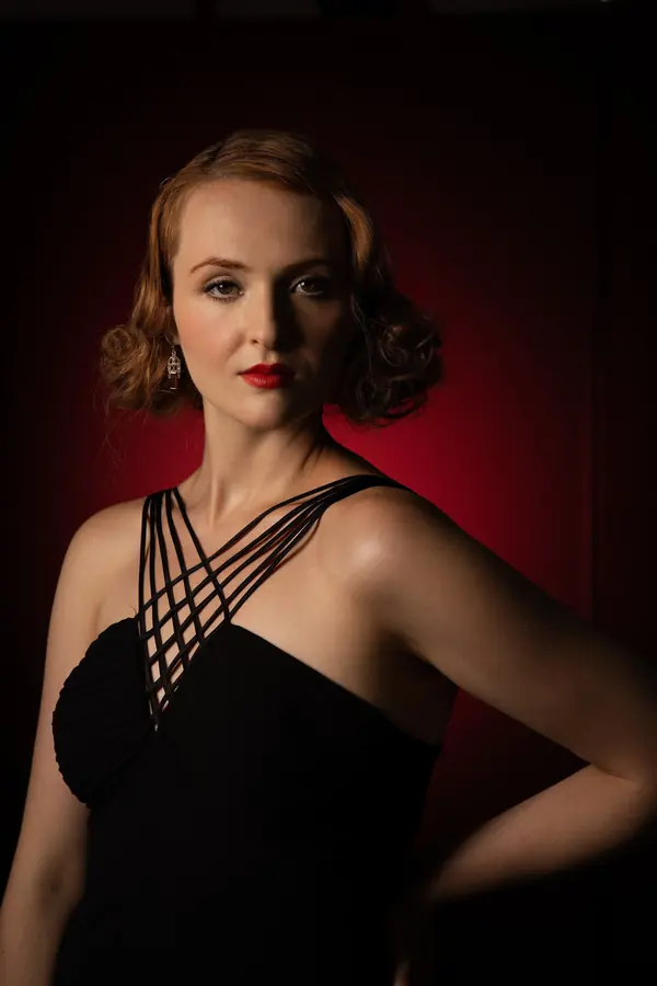 Vintage-styled portrait of a woman against a deep red backdrop