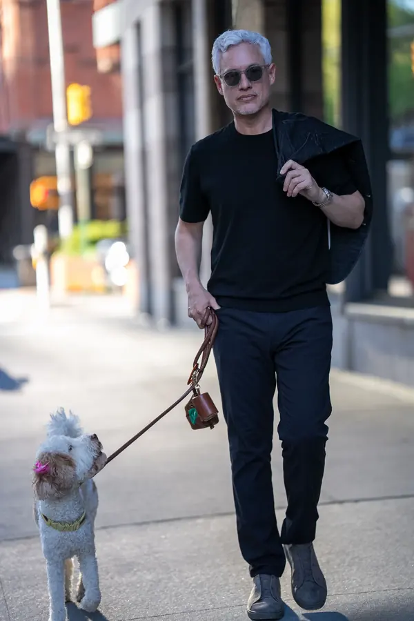 Man walking his dog down a downtown sidewalk